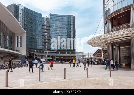 La gente della città di Milano cammina. Moderno grattacielo e piazza a Milano. Piazza Gae Aulenti. Foto Stock