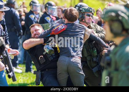 Bloomington, Stati Uniti. 25 aprile 2024. Dozzine di persone vengono arrestate dalla squadra antisommossa della polizia di Stato dell'Indiana durante una protesta filo-palestinese nel campus. I manifestanti avevano allestito un campo tenda a Dunn Meadow alle 11 del mattino e la polizia ha detto loro di abbattere le tende, o avrebbero sgomberato l'area con la forza e arrestato chiunque non se ne fosse andato. Tutti i manifestanti arrestati, compresi i professori, sono stati banditi dal campus dell'Indiana University per un anno. (Foto di Jeremy Hogan/SOPA Images/Sipa USA) credito: SIPA USA/Alamy Live News Foto Stock