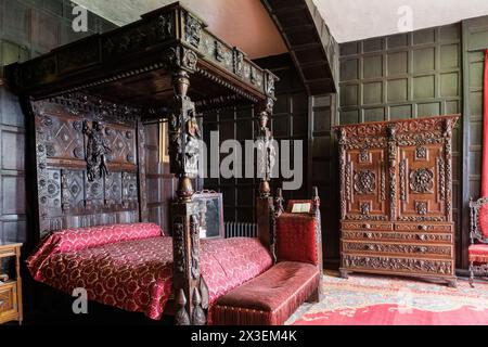 Letto storico a baldacchino e guardaroba a Speke Hall, residenza Tudor inserita nell'elenco di grado i del National Trust, Liverpool, Inghilterra, Regno Unito. Foto Stock