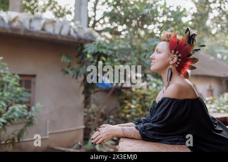 Una donna con un copricapo in piuma si siede sul grembo di mans per un evento elegante Foto Stock