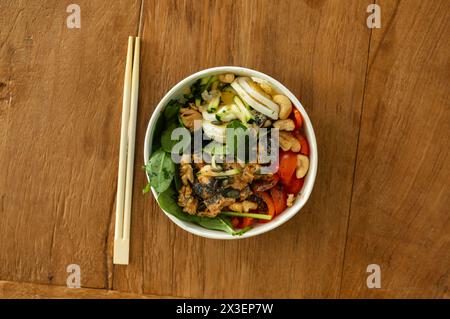 Vista dall'alto della colorata ciotola che serve piatti asiatici con bacchette Foto Stock