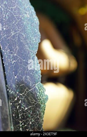 Coperto da incrinature e rottura del finestrino posteriore di un'auto in primo piano Foto Stock