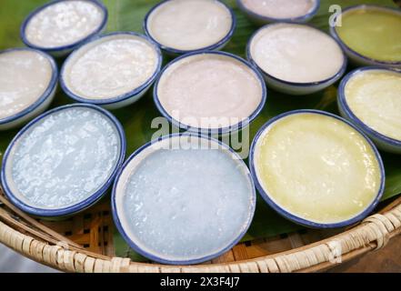 Gustoso dessert thailandese di Kanom Tuay Talai o budino al latte di cocco al vapore colorato e profumato con pisello di farfalla e Taro Foto Stock