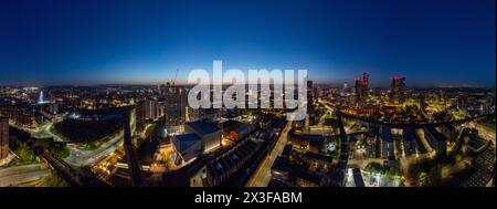 Questa immagine notturna presenta una vista aerea delle strade illuminate della città e della vivace vita urbana Foto Stock