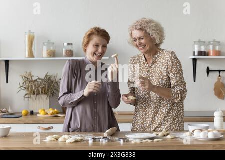 Famiglia intergenerazionale che si diverte preparando impasti fatti in casa per la pasticceria Foto Stock