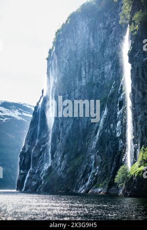 Foggy, nebbioso giorno di cielo soffiato con la cascata delle sette Sorelle in vista ritratto a Geiranger, Norvegia, Scandinavia con montagne sullo sfondo Foto Stock