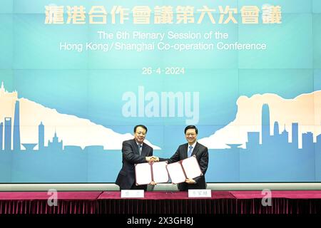 (240426) -- HONG KONG, 26 aprile 2024 (Xinhua) -- John Lee (R), amministratore delegato della regione amministrativa speciale di Hong Kong (HKSAR), e Gong Zheng, sindaco di Shanghai e vice capo del partito, firmano un memorandum d'intesa alla sesta sessione della conferenza di cooperazione Hong Kong/Shanghai a Hong Kong, Cina meridionale, 26 aprile 2024. La sesta sessione della Conferenza di cooperazione Hong Kong/Shanghai si è svolta qui venerdì, dove sono stati firmati 20 documenti di cooperazione nei settori dei servizi giuridici, del commercio, della finanza, della scienza e della tecnologia, dello sviluppo urbano, cultura e altri campi. (Reparto servizi informativi Foto Stock