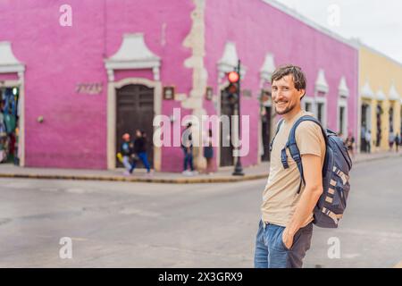 L'uomo turista esplora le vivaci strade di Valladolid, Messico, immergendosi nella ricca cultura e nell'architettura colorata di questo affascinante hotel Foto Stock