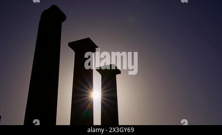 Sagome di antiche colonne di fronte a un cielo arancione luminoso al tramonto, Acropoli di Lindo, Lindo, Rodi, Dodecaneso, isole greche, Grecia Foto Stock