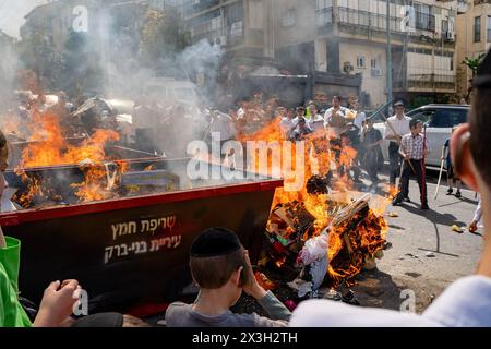 22 aprile 2024, Bnei Brak, Israele: Un incendio incendiato per bruciare il lievito durante il Biur Chametz. Durante il Biur Chametz, gli ebrei religiosi adempiono al loro obbligo di ispezionare le loro case per rilevare eventuali lieviti ed eliminarli prima della notte di Pesach. Nelle città ultra-ortodosse di Israele, gli incendi sono allestiti in luoghi importanti della città a questo scopo, dove le persone portano i loro avanzi di pane per bruciare il lievito. Durante i sette giorni di Pesach, è vietato loro mangiare o possedere qualsiasi lievito, simboleggiando la pasta che gli Israeliti non avevano il tempo di permettere di risorgere prima dell'Esodo dall'Egitto Foto Stock