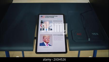 ZAPORIZHYA, UCRAINA - 15 MARZO 2024: Cabina di votazione presso la stazione di poling con tablet. Elenco dei candidati presidenziali statunitensi visualizzato sullo schermo. Moderna tecnologia di voto digitale. Giornata nazionale delle elezioni negli Stati Uniti d'America. Foto Stock