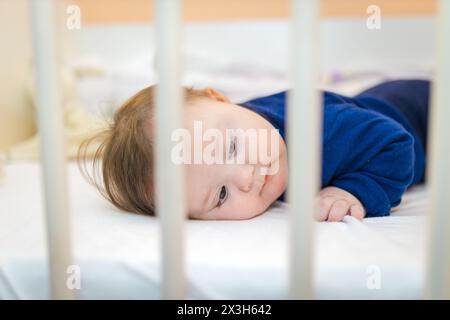 Cute Baby Girl Infant in piedi nel suo letto Foto Stock