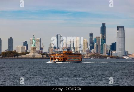 Traghetto per Staten Island a Hudson Riverbe vicino alla Statua della libertà con grattacieli di Jersey City, New Jersey alle spalle visto da Staten Island Ferry. Foto Stock
