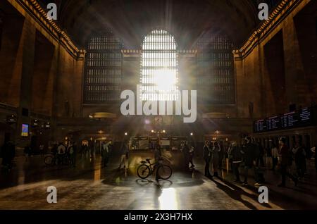 I raggi del sole irradiano sul Grand Central Terminal o sull'atrio principale della stazione, dando forma alle persone. Costruito in stile Beaux Arts a Midtown Manhattan, New York Foto Stock