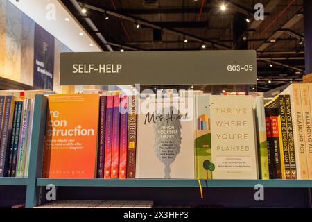 Sezione libri di auto-aiuto nella libreria Kinokuniya al Dubai Mall. Foto Stock