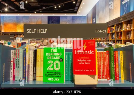 Sezione libri di auto-aiuto nella libreria Kinokuniya al Dubai Mall. Foto Stock