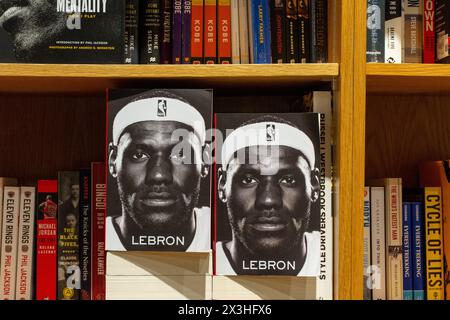 Le biografie di LeBron James su una libreria in legno nella sezione sport. Foto Stock