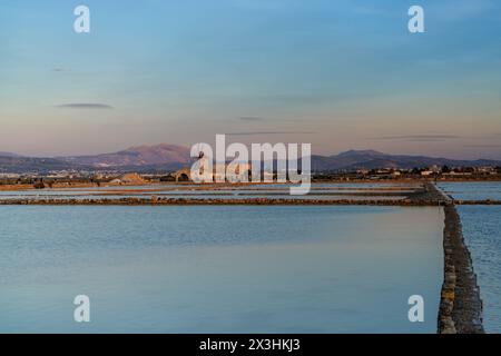 Paceco, Italia - 3 gennaio 2024: Vista del mulino a vento e del museo delle saline di Paceco al tramonto Foto Stock