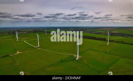 Vista aerea di un parco eolico con più turbine in un verde paesaggio rurale, che mostra una produzione energetica sostenibile. Foto Stock