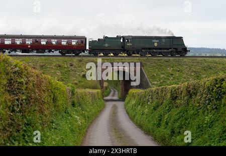 La locomotiva a vapore Battle of Britain Class No.34070 'Manston', tira carrozze da Ropley verso Alresford il secondo giorno del Spring Steam Gala sulla Mid Hants Railway, nota anche come Watercress line, nell'Hampshire. Data foto: Sabato 27 aprile 2024. Foto Stock