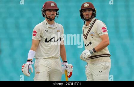 Londra. 27 aprile 2024. Rory Burns (17 Surrey Captain) e Cameron Steel (44 Surrey) in conversazione durante il secondo giorno del County Championship Division One match tra Surrey e Hampshire al Kia Oval. Crediti: Matthew Starling / Alamy Live News Foto Stock