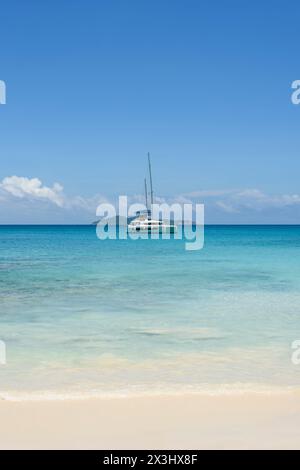 Yacht a vela ormeggiato al largo della spiaggia di Anse Lazio, dell'isola di Praslin, delle Seychelles, dell'Oceano Indiano Foto Stock