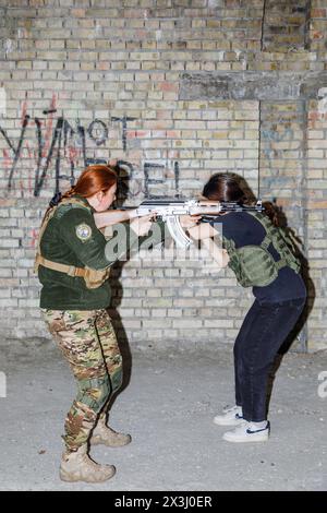 KIEV, UCRAINA - 13 aprile 2024: Le donne civili ucraine praticano con le armi mentre frequentano l'addestramento per le donne incentrate sull'uso di armi e kit medico di combattimento nel mezzo dell'invasione russa dell'Ucraina Foto Stock