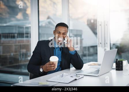 Uomo nero, ridendo e telefonando con un caffè per scherzare, discutere o comunicare in ufficio. Felice uomo d'affari, contabile o dipendente sorride Foto Stock