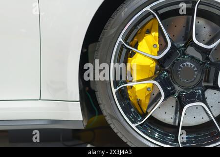 auto sportiva ad alte prestazioni con questa foto dettagliata del cerchio in lega, che mostra freni da corsa di precisione e pinze vibranti Foto Stock