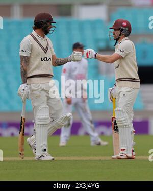 Londra. 27 aprile 2024. Rory Burns (17 Surrey Captain) e Jordan Clark (16 Surrey)pugno durante il secondo giorno della partita County Championship Division One tra Surrey e Hampshire al Kia Oval. Crediti: Matthew Starling / Alamy Live News Foto Stock