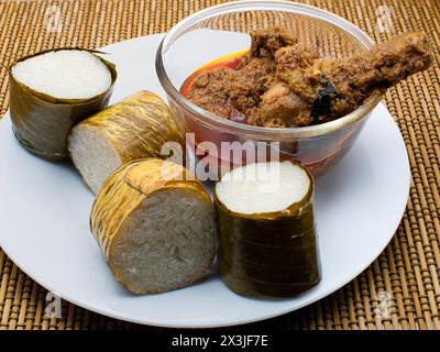 Alimenti tradizionali Lemang a base di riso glutinoso, latte di cocco e sale, cotti in una tubatura di bambù scavata ricoperta di foglie di banana per prevenire Foto Stock