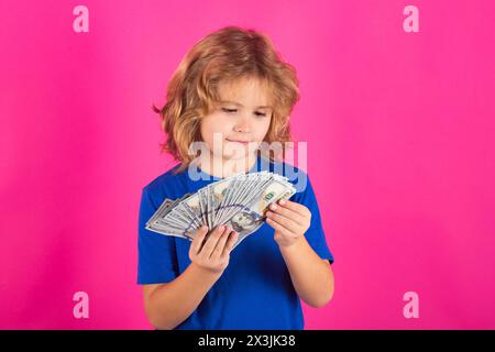 I soldi vincono, grande fortuna. Ragazzo che mostra banconote da soldi, sogna di ricchi su un ambiente isolato in studio Foto Stock