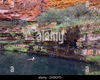 KARIJINI, AUSTRALIA occidentale - 10 LUGLIO 2018: Donna che nuota nelle fredde acque della Circular Pool a Dales Gorge, Karijini, Australia Occidentale Foto Stock