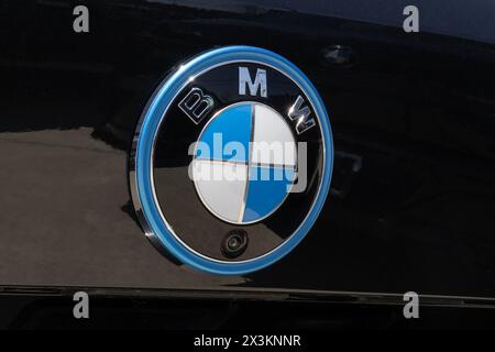 Lafayette - 25 aprile 2024: Logo BMW con un anello blu che rappresenta un veicolo elettrico EV su uno sfondo verniciato nero. Foto Stock