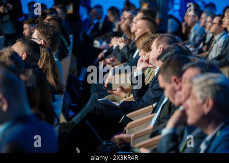 Gruppo eterogeneo di professionisti che ascoltano attentamente un oratore durante una conferenza. Concentrarsi sul coinvolgimento del pubblico e sullo sviluppo professionale. Foto Stock