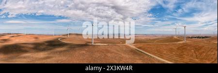 Mulini a vento che generano energia elettrica sulle cime delle colline del remoto entroterra dell'Australia meridionale - panoramico panorama aereo. Foto Stock