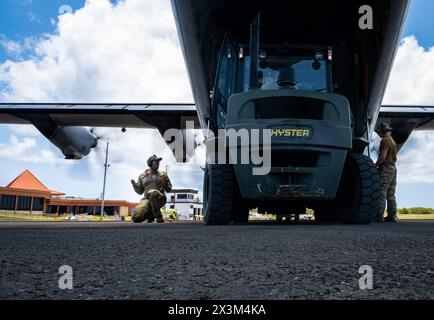 Il Senior Airman Elijah Palmer (a sinistra) dell'aeronautica statunitense, un comandante del carico assegnato al 36th Airlift Squadron fuori dalla base aerea di Yokota, in Giappone, dirige il carico su un C-130 Hercules durante la fase di riaggregazione dell'esercitazione Agile Reaper 24-1 a Tinian Spoke, Isole Marianne Settentrionali, 17 aprile 2024. Circa 800 avieri della U.S. Air Force volarono, mantennero e supportarono 29 aerei che operavano in cinque località disaggregate durante l'AR 24-1. L’esercitazione ha impiegato ruoli e processi rappresentativi del combattimento per indirizzare deliberatamente tutti i partecipanti come pubblico di addestramento e sottolineare la capacità della forza di g Foto Stock