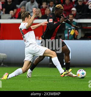 Leverkusen, Germania. 27 aprile 2024. Victor Boniface (R) del Bayer 04 Leverkusen visse con Anthony Rouault del VfB Stuttgart durante il match di prima divisione della Bundesliga tra Bayer 04 Leverkusen e VfB Stuttgart a Leverkusen, Germania, 27 aprile 2024. Crediti: Ulrich Hufnagel/Xinhua/Alamy Live News Foto Stock