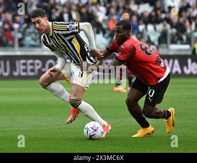 Torino, Italia. 27 aprile 2024. Lo Yunus Musah (R) dell'AC Milan affronta con Dusan Vlahovic del FC Juventus durante una partita di calcio di serie A tra il FC Juventus e l'AC Milan a Torino, Italia, 27 aprile 2024. Crediti: Alberto Lingria/Xinhua/Alamy Live News Foto Stock