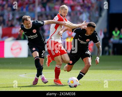 Monaco, Germania. 27 aprile 2024. Konrad Laimer (C) del Bayern Monaco visse con Mario Goetze (L) e Tuta di Francoforte durante la partita di calcio tedesca di prima divisione tra Bayern Monaco e Eintracht Frankfurt a Monaco, Germania, 27 aprile 2024. Crediti: Philippe Ruiz/Xinhua/Alamy Live News Foto Stock