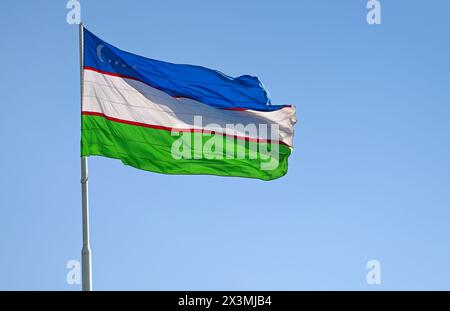 Bandiera uzbeka o bandiera uzbeka contro il cielo blu Foto Stock