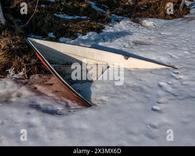 barca sepolta sotto la neve e il ghiaccio sulla riva Foto Stock