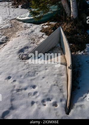 barca sepolta sotto la neve e il ghiaccio sulla riva Foto Stock