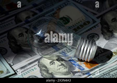 La lampada a incandescenza si trova all'ombra, ad alto prezzo dell'elettricità, al business Foto Stock