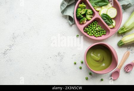 Alimenti sani per bambini nel recipiente. Purea di verdure con broccoli e piselli Foto Stock