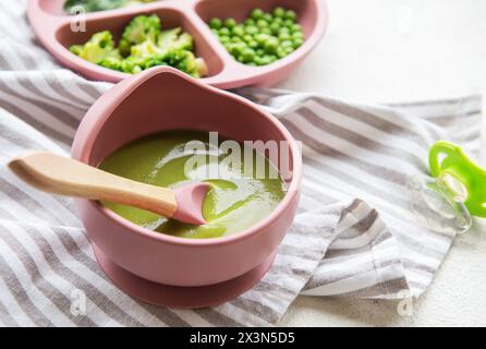 Alimenti sani per bambini nel recipiente. Purea di verdure con broccoli e piselli Foto Stock