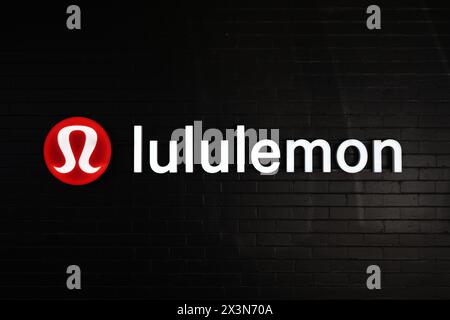 Insegna lululemon illuminata su una parete di mattoni neri, fuori da uno dei loro negozi di Melbourne Foto Stock