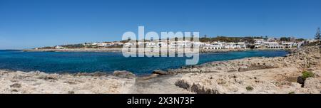 Fotografía panorámica de la cala de Biniancolla en la isla de Menorca, que ofrece un pintoresco paisaje de típicas casas blancas. España Foto Stock