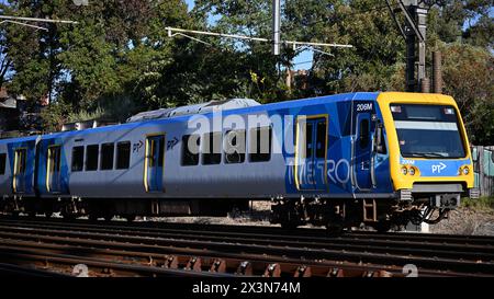 Vista laterale di un treno X'Trapolis 100, gestito da treni della metropolitana, che viaggia attraverso i sobborghi interni di Melbourne in una giornata di sole Foto Stock