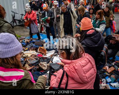 Amsterdam, Paesi Bassi. 27 aprile 2024. Si vedono persone che circondano una delle bancarelle del mercato. Il King's Day è rinomato per essere uno dei festeggiamenti più grandi e colorati del paese, specialmente ad Amsterdam. La città è piena di arancio, mentre la gente si diverte con la festa di strada più grande dell'anno, godendosi i mercati liberi e divertendosi sulle barche lungo i canali. (Foto di Ana Fernandez/SOPA Images/Sipa USA) credito: SIPA USA/Alamy Live News Foto Stock